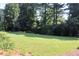 Expansive, lush green backyard surrounded by mature trees, perfect for outdoor enjoyment at 5974 Sw Four Winds Sw Dr, Lilburn, GA 30047
