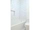 Updated bathroom shower with white subway tile and recessed niche at 5974 Sw Four Winds Sw Dr, Lilburn, GA 30047