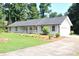 Cozy single-story home with a welcoming front porch and a well-manicured lawn and driveway at 5974 Sw Four Winds Sw Dr, Lilburn, GA 30047