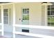 Close-up of a charming light blue front door with sidelight windows and white railing at 5974 Sw Four Winds Sw Dr, Lilburn, GA 30047