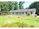 Beautiful single-story home with a lush green lawn and colorful flowerbeds at 5974 Sw Four Winds Sw Dr, Lilburn, GA 30047