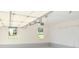 Clean, two-car garage featuring windows and automatic door opener at 5974 Sw Four Winds Sw Dr, Lilburn, GA 30047