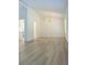 Open living room with wood-look floors, high ceilings, and modern light fixture at 5974 Sw Four Winds Sw Dr, Lilburn, GA 30047