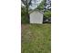Backyard with a small storage shed, green grass, and outdoor seating, offering a functional outdoor space at 6265 Gemstone Ct, South Fulton, GA 30349