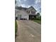 Charming two-story home featuring a well-manicured lawn and a long driveway leading up to the house at 6265 Gemstone Ct, South Fulton, GA 30349