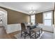 Dining room featuring decorative wainscoting, modern lighting, and a long wooden table at 935 Grove Valley Drive Dr, Cumming, GA 30041