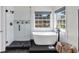 Beautiful bathroom featuring freestanding tub, glass-enclosed shower, and sleek black marble floors at 499 Running Doe Ct, Suwanee, GA 30024
