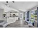 Open-concept living area features modern kitchen, breakfast bar, plenty of natural light, and cozy seating area at 499 Running Doe Ct, Suwanee, GA 30024