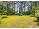 Expansive backyard with lush green grass and mature trees, providing privacy and a serene environment at 824 Hickory Ridge Sw Rd, Lilburn, GA 30047
