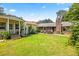 A green backyard featuring a patio set, outbuildings, mature trees, and ample room for recreation at 824 Hickory Ridge Sw Rd, Lilburn, GA 30047