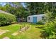 View of backyard and shed in a grassy yard with mature trees and a rustic foot bridge feature at 824 Hickory Ridge Sw Rd, Lilburn, GA 30047