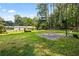 Large backyard featuring a basketball court and mature trees, offering ample space for outdoor activities at 824 Hickory Ridge Sw Rd, Lilburn, GA 30047