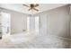 Spacious carpeted bedroom with white trim, ceiling fan, ensuite bath, and multiple closets at 824 Hickory Ridge Sw Rd, Lilburn, GA 30047