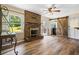 Open living room with a brick fireplace, hardwood floors, and a door to the laundry at 824 Hickory Ridge Sw Rd, Lilburn, GA 30047