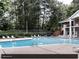 Large community swimming pool and deck with lounge chairs surrounded by mature trees at 22 Dunwoody Springs Dr, Atlanta, GA 30328