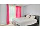Bedroom with neutral colored walls and a large window with vibrant pink curtains at 2233 Hansford Pass, Buford, GA 30519