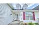 Close up of front door entrance featuring sidelight windows and decorative hanging plants; beautiful curb appeal at 2233 Hansford Pass, Buford, GA 30519