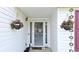 Close-up of the front door with hanging flower baskets and decorative hanging art at 2233 Hansford Pass, Buford, GA 30519