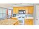 Lovely kitchen boasts warm cabinetry, white appliances, and a stylish island countertop at 2233 Hansford Pass, Buford, GA 30519
