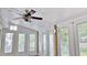 This sunny sunroom has wood floors, white trim, lots of windows, and a ceiling fan at 2233 Hansford Pass, Buford, GA 30519