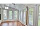 Bright sunroom featuring wood floors, white trim, and many windows with natural light at 2233 Hansford Pass, Buford, GA 30519