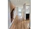 Inviting hallway with gleaming hardwood floors, staircase, and view into the living area and kitchen at 3948 Oak Glenn Dr, Duluth, GA 30096