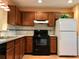 Functional kitchen featuring wood cabinets, black appliances, and ample counter space for meal preparation at 3948 Oak Glenn Dr, Duluth, GA 30096