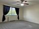 A spacious bedroom bathed in natural light, featuring neutral walls, a ceiling fan and gray carpeting at 2479 Peachtree Ne Rd # 317, Atlanta, GA 30305
