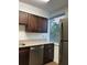 Bright kitchen featuring stainless steel appliances, brown cabinetry, granite countertops, and a window at 2479 Peachtree Ne Rd # 317, Atlanta, GA 30305
