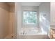 Bright bathroom with a large garden tub, shower, and window at 5033 Kens Ct, Stockbridge, GA 30281