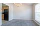 Open-concept dining area featuring neutral paint, plush carpet, and an adjacent kitchen with black appliances at 5033 Kens Ct, Stockbridge, GA 30281