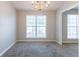 Cozy dining room with neutral paint, plush carpet, a modern chandelier, and ample natural light at 5033 Kens Ct, Stockbridge, GA 30281