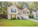 Charming two-story home with a manicured lawn, brick accents, and attached two-car garage at 5033 Kens Ct, Stockbridge, GA 30281