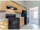 Functional kitchen featuring wooden cabinets, black appliances, neutral countertops, and natural light at 5033 Kens Ct, Stockbridge, GA 30281