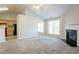 Bright living room with a fireplace, vaulted ceilings, neutral paint, plush carpet, and natural light at 5033 Kens Ct, Stockbridge, GA 30281