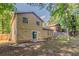 View of the home's backyard with partial lawn, patio, mature trees, and fenced perimeter at 5383 Forest East Ln, Stone Mountain, GA 30088