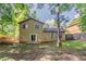 View of the home's backyard with partial lawn, patio, mature trees, and fenced perimeter at 5383 Forest East Ln, Stone Mountain, GA 30088