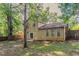 View of the home's backyard with partial lawn, mature trees, and fenced perimeter at 5383 Forest East Ln, Stone Mountain, GA 30088