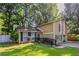 Charming two-story home featuring a well-manicured lawn, wood siding, and a welcoming front entrance with black railing at 5383 Forest East Ln, Stone Mountain, GA 30088