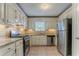 Classic kitchen featuring granite countertops, white cabinets, stainless steel appliances, and tiled floors at 5383 Forest East Ln, Stone Mountain, GA 30088