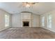 Carpeted living room featuring a vaulted ceiling, fireplace, and large windows allowing natural light at 5383 Forest East Ln, Stone Mountain, GA 30088