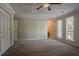 Spacious main bedroom featuring a ceiling fan, carpet, and two windows for lots of natural light at 5383 Forest East Ln, Stone Mountain, GA 30088