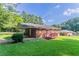 Enjoy a spacious backyard with a brick house, wooden deck and lush green lawn at 573 Allgood Rd, Stone Mountain, GA 30083