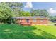 Enjoy a spacious backyard with a brick house, wooden deck and lush green lawn at 573 Allgood Rd, Stone Mountain, GA 30083