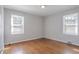 Bright bedroom features beautiful hardwood floors and two windows for ample natural light at 573 Allgood Rd, Stone Mountain, GA 30083