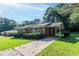 Inviting brick home featuring a carport and green, manicured landscaping at 573 Allgood Rd, Stone Mountain, GA 30083