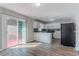 Open kitchen with white cabinets, a black refrigerator, and access to the deck at 573 Allgood Rd, Stone Mountain, GA 30083