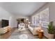 Bright living room featuring a striped rug, white furniture and large windows at 573 Allgood Rd, Stone Mountain, GA 30083
