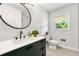 Modern bathroom with sleek vanity, round mirror, and natural light at 4103 Laynewood Cir, Tucker, GA 30084
