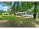 A white-painted brick home is framed by lush greenery and a spacious lawn in a tranquil setting at 4103 Laynewood Cir, Tucker, GA 30084